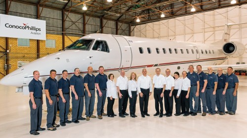 Members of ConocoPhillips’ Global Aviation Services organization gather in front of the company’s Embraer ERJ135 jet at the Bartlesville Municipal Airport. 